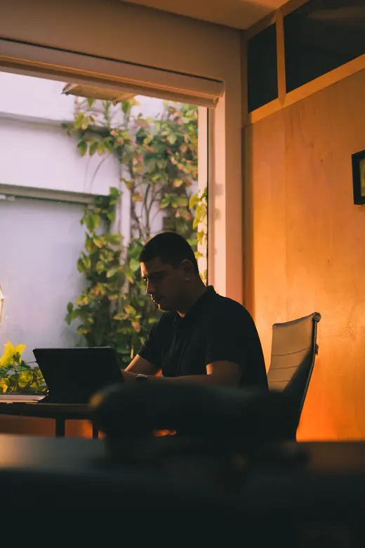 Felipe trabalhando no notebook, perto da janela do consultório